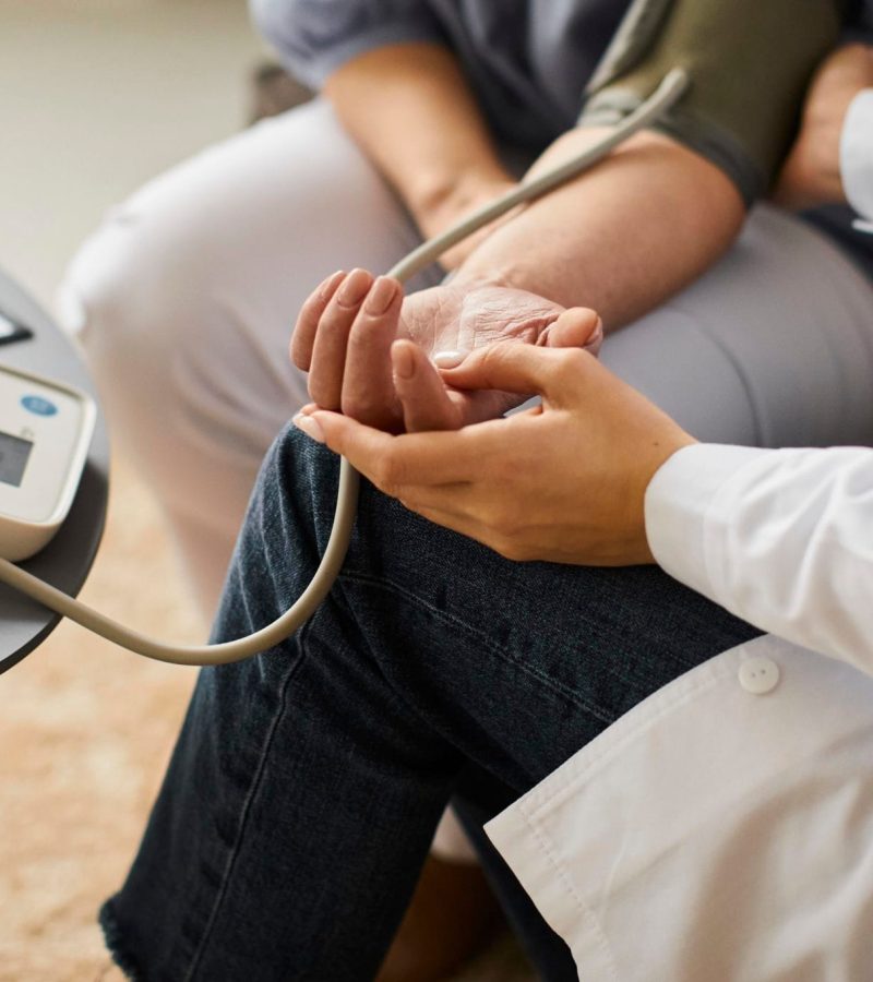 high-angle-covid-recovery-center-female-doctor-checking-elder-patient-s-blood-pressure